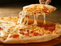 Gorąca pizza z ciągnącym się serem i pepperoni na desce.