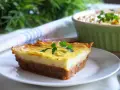 Wegańska zapiekanka pasterska z ziemniaczanym puree i warzywnym farszem, udekorowana natką pietruszki.