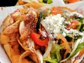 Kebab z kurczakiem, warzywami i serem feta w bułce.