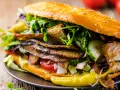 Duży kebab w bułce z mięsem, warzywami i pikantną papryczką.