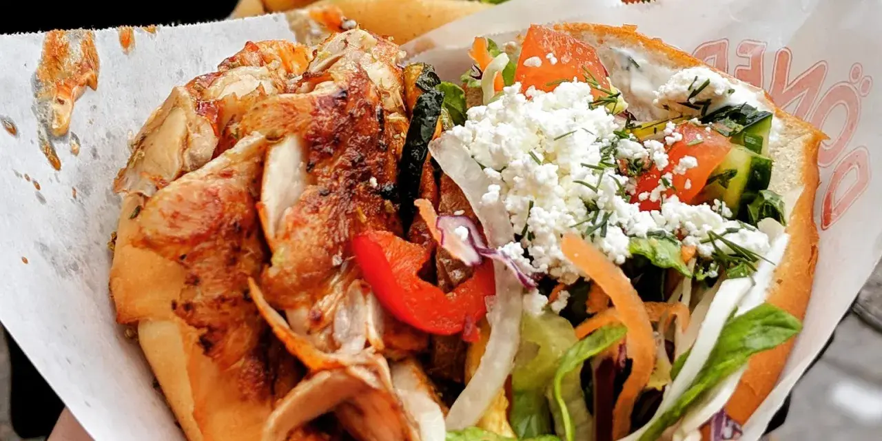 Kebab z kurczakiem, warzywami i serem feta w bułce.
