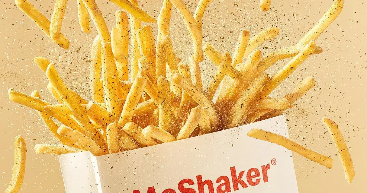 McShaker Fries wysypujące się z pudełka, posypane przyprawami.