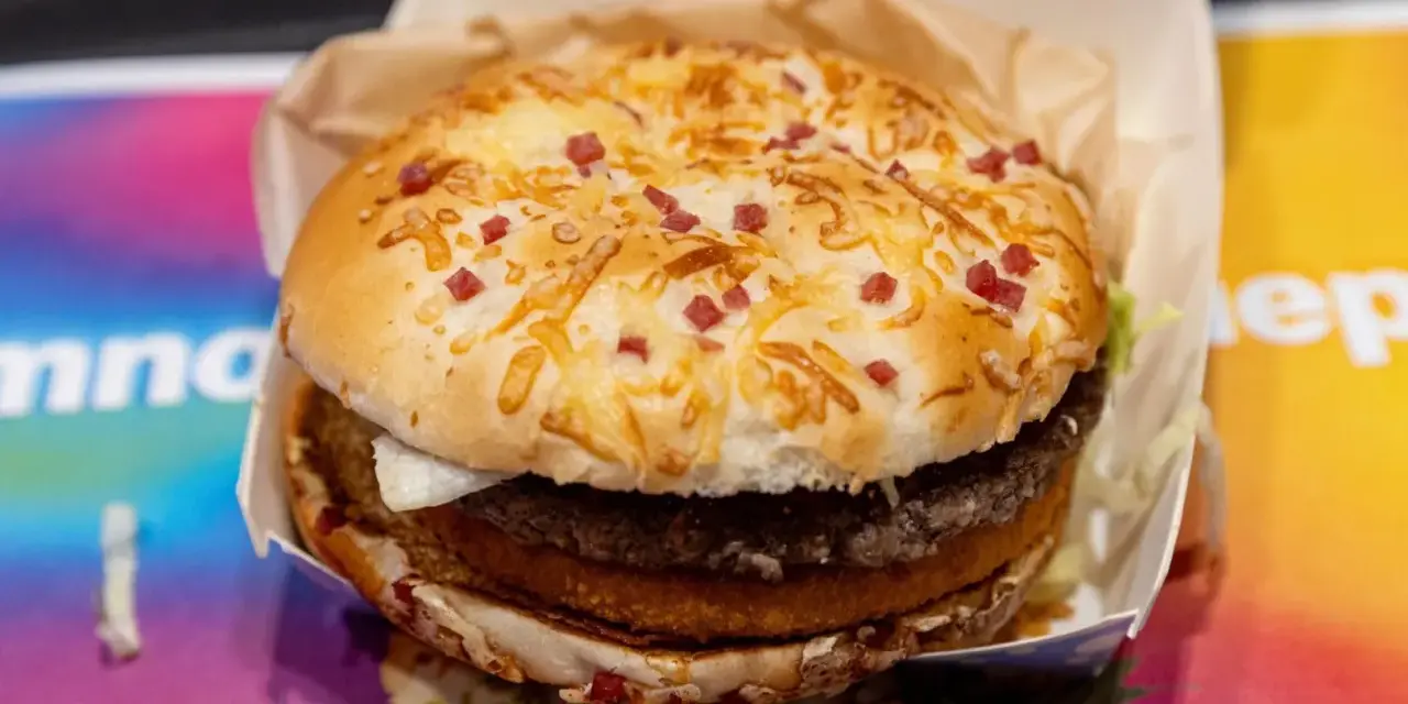 Burger Drwala z podwójnym mięsem, serem i kawałkami bekonu na bułce.