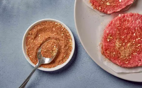 Mielone mięso na burgery z przyprawami w miseczce i na talerzu.