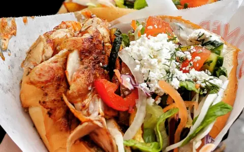 Kebab z kurczakiem, warzywami i serem feta w bułce.
