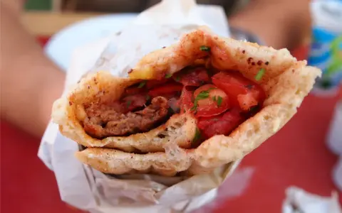 Dürüm kebab z mięsem mielonym, pomidorami i ziołami w bułce.