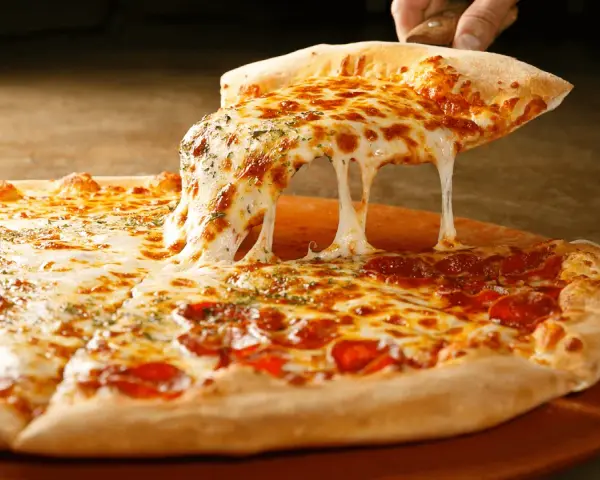 Gorąca pizza z ciągnącym się serem i pepperoni na desce.