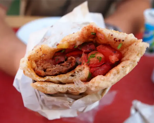 Dürüm kebab z mięsem mielonym, pomidorami i ziołami w bułce.