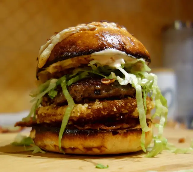 Apetyczny, domowy burger z podwójnym kotletem, serem i chrupiącą sałatą.