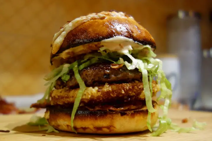 Apetyczny, domowy burger z podwójnym kotletem, serem i chrupiącą sałatą.