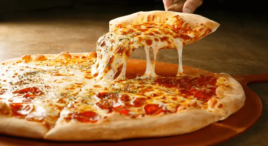 Gorąca pizza z ciągnącym się serem i pepperoni na desce.