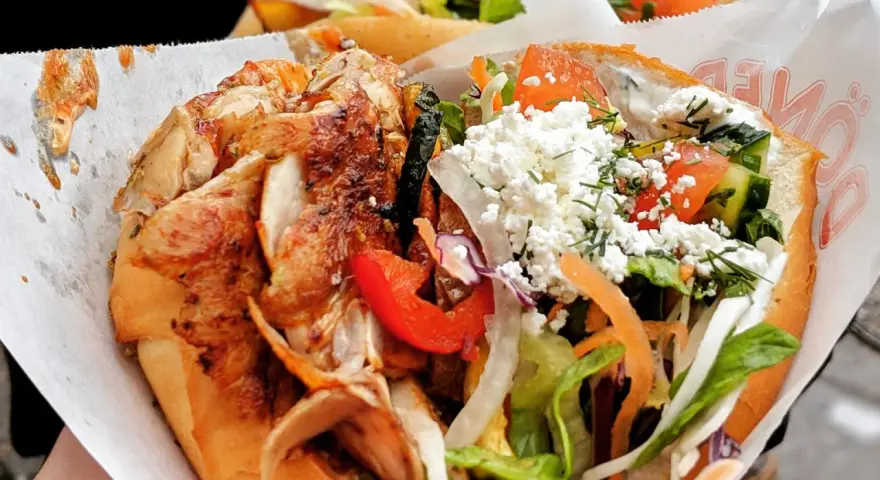 Kebab z kurczakiem, warzywami i serem feta w bułce.