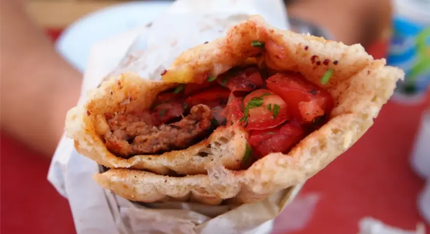 Dürüm kebab z mięsem mielonym, pomidorami i ziołami w bułce.