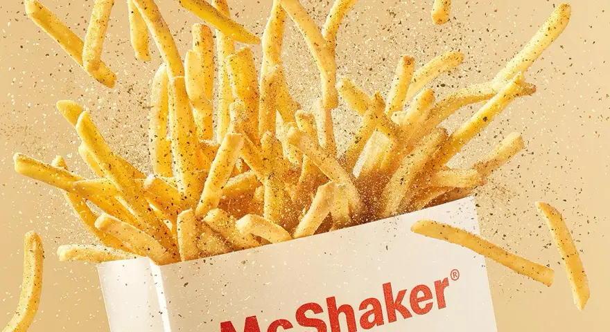 McShaker Fries wysypujące się z pudełka, posypane przyprawami.