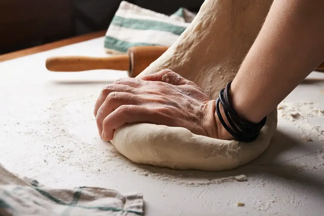 rozciąganie ciasta na pizzę rękami